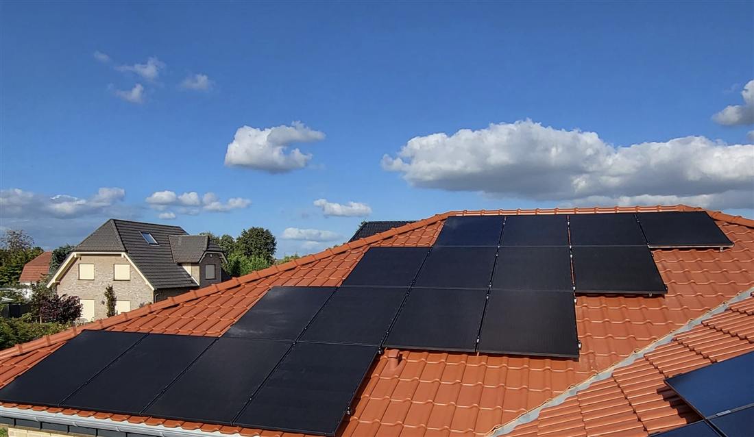 PV-Anlage mit Full-Black-Modulen auf rotem Satteldach, versetzte Belegung über zwei Dachflächen
